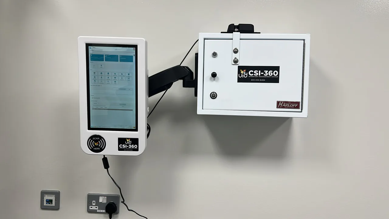 CSI-360 touchscreen on an articulating wall arm beside a compact wall-mounted white controlled-substance cabinet
